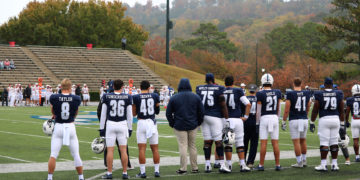 Samford Bulldogs stand on the sidelines, ready to play.
