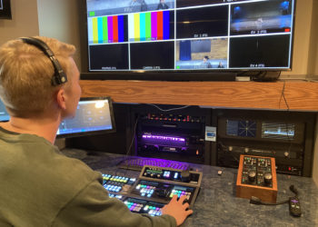 Chris Todd, the production crew's technical director, sits at a control board.