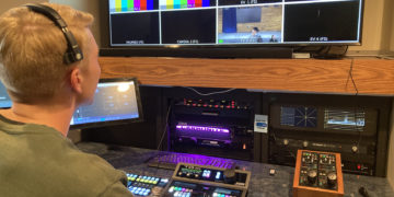 Chris Todd, the production crew's technical director, sits at a control board.
