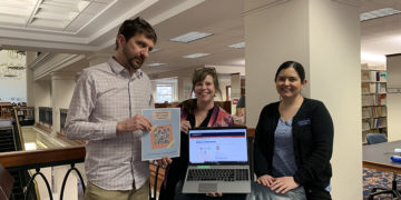 Lance Day (left), Lauren Young (center) and Sarah Cooper (right) show off library resources.