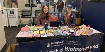 Madeline Thompson (left) and Shelby Kuck (right) sell homemade cards for Valentine's Day.