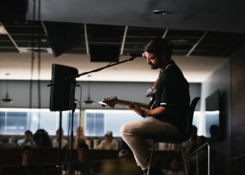 Jervis Campbell strums away on his guitar.