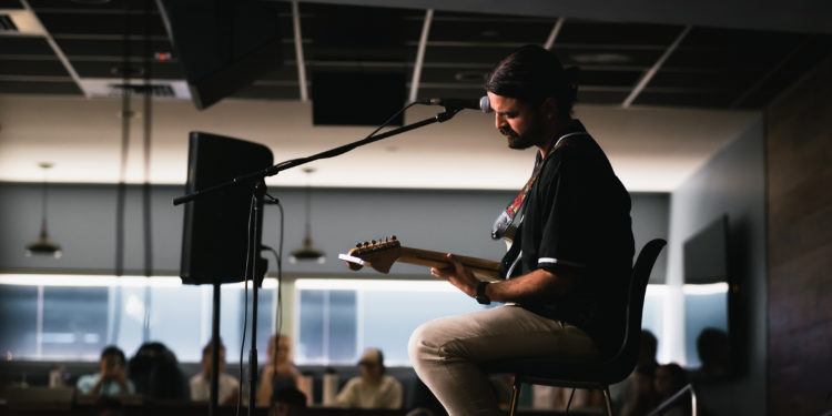 Jervis Campbell strums away on his guitar.